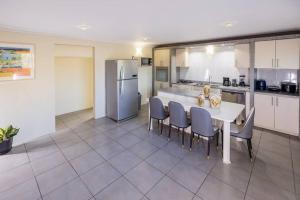 a kitchen with a table and chairs and a refrigerator at Enjoyment Villa Cataleya in Oranjestad