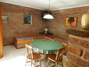 ein Zimmer mit einem Tisch, Stühlen und einer Ziegelwand in der Unterkunft La Posada de Gogg Cabañas in Bella Vista