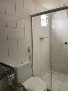 biała łazienka z prysznicem i toaletą w obiekcie Bangalos do Pontal w mieście Japaratinga