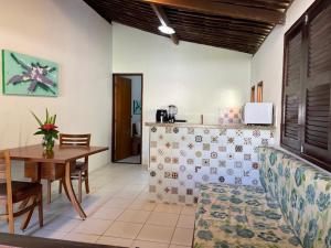 a living room with a table and a dining room at Bangalos do Pontal in Japaratinga