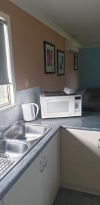 cocina con fregadero y microondas en The Heights Bed & Breakfast, en Jurien Bay