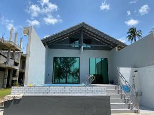 a white house with stairs and a swimming pool at Amnis Tiny House in Bachok