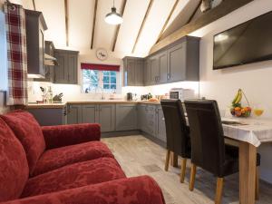 a kitchen with a red couch and a table and chairs at Kingfisher Cottage in Wainfleet All Saints