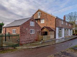 an old brick house with a fence in front of it at Kingfisher Cottage in Wainfleet All Saints