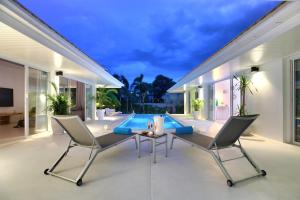 un patio con mesa y sillas y una piscina en 700m from beach & luxury, en Koh Samui 