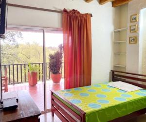 a bedroom with a bed and a large window at Finca Hotel La Ponderosa in Rionegro