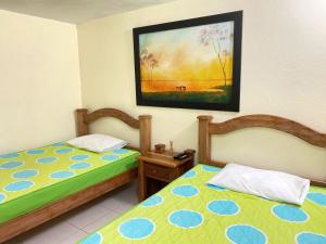 um quarto com duas camas e uma foto na parede em Finca Hotel La Ponderosa em Rionegro
