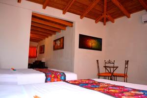 a bedroom with two beds and a table and chairs at Hotel Aldama in Colima