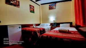 Habitación de hotel con 2 camas con sábanas rojas en Hostal sambleño cusco Piero suite, en Cusco