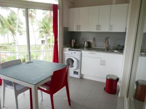 a kitchen with a table and a sink and a washing machine at STUDIO Coquillages&Crustacés in Le Gosier