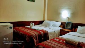 a hotel room with two beds and a telephone at Hostal sambleño cusco Piero suite in Cusco