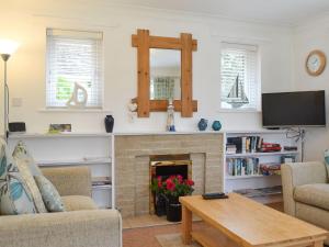 sala de estar con chimenea y TV en The Cottage At Boscobel en Brockenhurst