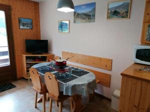 a dining room with a table and chairs and a television at Appartement Le Grand-Bornand, 1 pièce, 4 personnes - FR-1-241-242 in Le Grand-Bornand