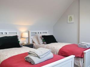 a bedroom with two beds with red and white blankets at Little Vines in Strensham