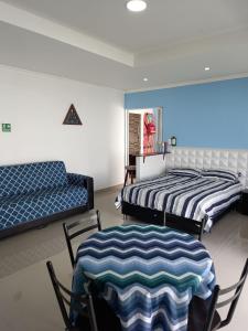 two beds in a room with chairs and a couch at Holiday Loft Suite Apartamento in San Andrés