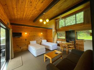 Zimmer mit 2 Betten, einem Sofa und einem Tisch in der Unterkunft Lakes Lodge Okataina in Rotorua