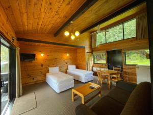 a room with two beds and a couch and a table at Lakes Lodge Okataina in Rotorua