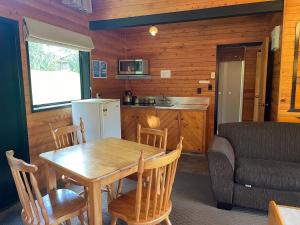 羅托魯阿的住宿－Lakes Lodge Okataina，厨房以及带桌子和沙发的用餐室。