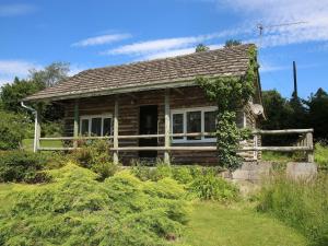 uma pequena cabana de madeira com um alpendre em The Garden House - Uk10987 em Llandogo