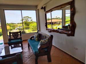 a living room with two chairs and a mirror at Casa Campestre Denis in Guamal