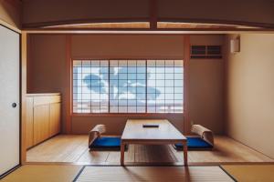 a room with a table and chairs and a window at Ryokan Motonago in Kyoto