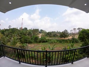 a balcony with a view of a field at Pinnawala Elephant Front View Hotel in Rambukkana
