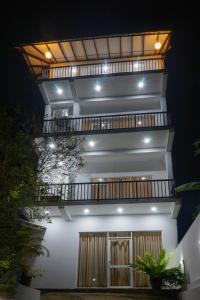 a white house with a balcony at night at Pinnawala Elephant Front View Hotel in Rambukkana