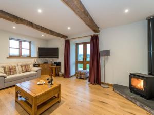 a living room with a couch and a fireplace at Ysgubor in Efenechtyd