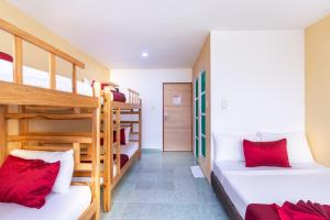 a room with two bunk beds and red pillows at Hotel Portobahia Santa Marta Rodadero in Santa Marta