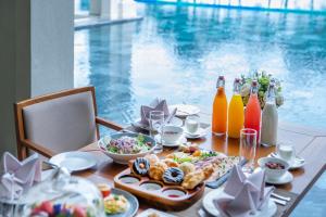 FLC Luxury Resort Samson في سام سون: طاولة مع طعام وزجاجات عصير ومشروبات
