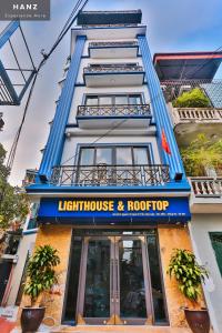 HANZ Light House Hotel & Apartment في هانوي: مبنى به منزل خفيف وقمة في السطح