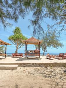 a group of benches sitting on the beach at Nusa Indah Bungalows in Gili Air