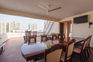 a dining room with a table and chairs and a balcony at Achates Corporate Services in Bangalore