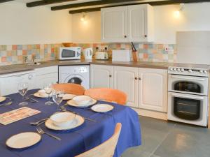 a kitchen with a table with a blue table cloth at Culvada in Treknow