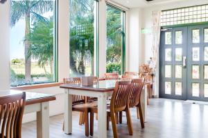 a dining room with a table and chairs and windows at Summer Garden in Taitung City