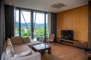 a living room with a couch and a tv at Khaoyai Luxury Pool Penthouse at ATTA in Pak Chong