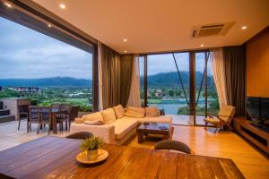a living room with a couch and a table at Khaoyai Luxury Pool Penthouse at ATTA in Pak Chong