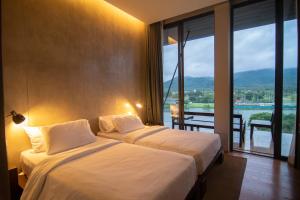 two beds in a hotel room with a large window at Khaoyai Luxury Pool Penthouse at ATTA in Pak Chong +22 photos