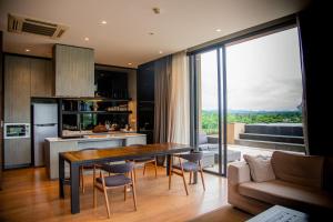 Pak Chong的住宿－Khaoyai Luxury Pool Penthouse at ATTA，厨房以及带桌椅的起居室。