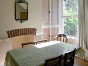 uma sala de jantar com uma mesa e cadeiras e uma janela em Cranmere em Salcombe