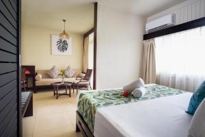 a hotel room with a bed and a living room at Fiji Gateway Hotel in Nadi
