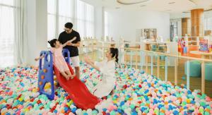two people playing in a large pile of balls at FLC Luxury Hotel Samson in Sầm Sơn