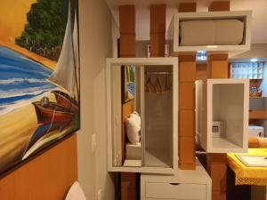 a bathroom with a mirror and a painting on the wall at Ilusion Flats Aconchego de Ponta Negra in Natal