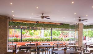 a restaurant with tables and chairs and a large window at Hotel Portobahia Santa Marta Rodadero in Santa Marta