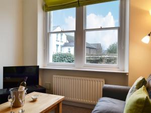 - un salon avec un canapé et une grande fenêtre dans l'établissement Poets Retreat, à Cockermouth
