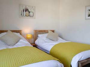 dos camas sentadas una al lado de la otra en una habitación en Poets Retreat, en Cockermouth