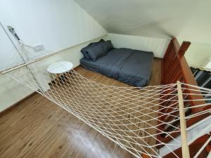 eine Hängematte in einem Zimmer mit einem Bett in der Unterkunft Amnis Tiny House in Bachok