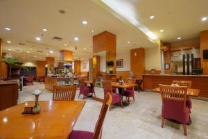 a restaurant with tables and chairs and a bar at Hotel Bisanta Bidakara Tunjungan in Surabaya