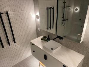 a white bathroom with a sink and a shower at Arlberg 314 in Mount Buller
