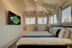 a bedroom with a bed with a view of a baseball game at LUXURY PENTHOUSE GREAT LOCATION WITH PARKING Tlv in Ramat Gan